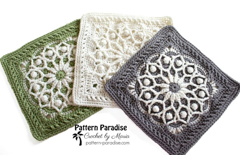 May include: Three square crochet pieces in shades of green, white, and gray. Each piece features a detailed, floral-like pattern in the center, surrounded by a textured border. The pieces are likely handmade and showcase intricate stitch work.