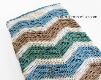 May include: A crocheted chevron blanket in shades of blue, green, brown, and white. The blanket has a lacy pattern and is made with a soft yarn.