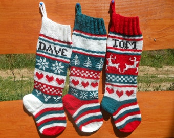 May include: Three knitted Christmas stockings with different designs. The stocking on the left is white with red and green stripes and has the name "DAVE" knitted on it. The middle stocking is white with green and red stripes and has a pattern of Christmas trees. The stocking on the right is red with green and white stripes and has the name "TOMI" knitted on it and a pattern of reindeer.