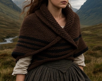 May include: A woman wearing a brown knitted shawl with black stripes, a white blouse, and a dark gray skirt. The scene is set in a mountainous, grassy landscape under an overcast sky. The shawl is wrapped around the shoulders.
