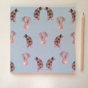 May include: A light blue background with a repeating pattern of brown bears balancing on balls. The bears are riding on small tricycles.