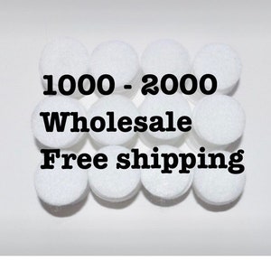 May include: A close-up of a group of white round felt circles. The text "1000 - 2000 Wholesale Free shipping" is printed in black on the felt circles.