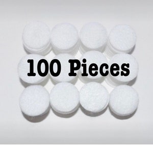 May include: 100 white felt circles, each about 1 inch in diameter. The circles are stacked in a pile, with the text "100 Pieces" printed in black on a white background.