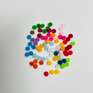May include: Assortment of colorful felt circles in various shades of blue, green, red, orange, yellow, pink, and white. The circles are scattered on a white background.
