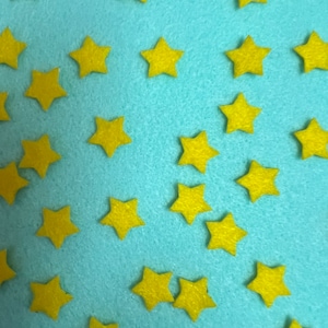 May include: A blue background with yellow felt stars scattered across the surface.