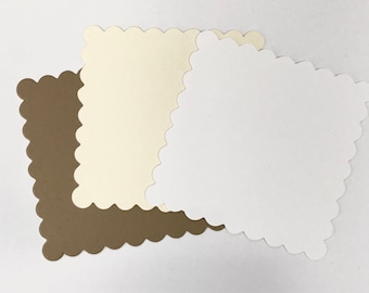 May include: Three scalloped square cards in different colors: brown, cream, and white.