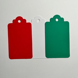 May include: Three blank gift tags with scalloped edges. The tags are red, white, and green.