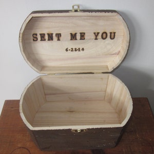 May include: A wooden box with a hinged lid, painted brown. The lid is open and the inside of the box is made of light wood. The lid has the words "SENT ME YOU" and the date "6-28-14" burned into the wood.
