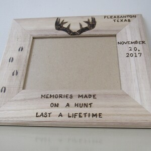 May include: A wooden picture frame with a burnt-in design of deer antlers and footprints. The frame has the text "Memories Made On A Hunt Last A Lifetime" and "Pleasanton Texas November 20, 2017".