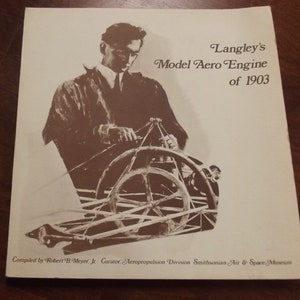 May include: A black and white photo of a man working on a model aero engine. The caption reads "Langley's Model Aero Engine of 1903".