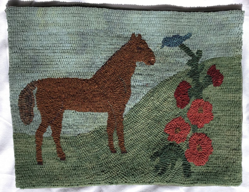 May include: A brown horse stands on a green field with a blue bird perched on a red flower stem. The background is a light blue sky.