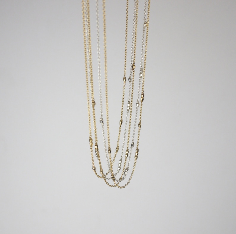 May include: A layered necklace with alternating gold and silver beads.