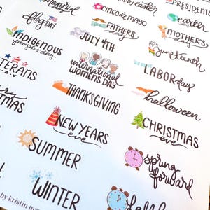 May include: A sheet of holiday-themed stickers with various text designs. The stickers include phrases like "Happy Easter," "July 4th," "Thanksgiving," and "Christmas Eve." The designs feature colorful illustrations and handwritten fonts.
