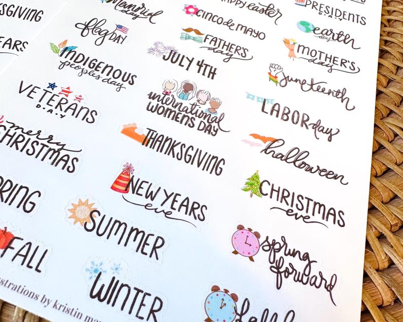 May include: A sheet of holiday-themed stickers with various text designs. The stickers include phrases like "Happy Easter," "July 4th," "Thanksgiving," and "Christmas Eve." The designs feature colorful illustrations and handwritten fonts.