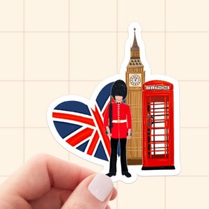 Op de afbeelding: Een sticker met Londense bezienswaardigheden. Het bevat een hartvormige Union Jack, Big Ben, een rode telefooncel en een Royal Guard in een rood uniform. Het ontwerp is een kleurrijke illustratie.