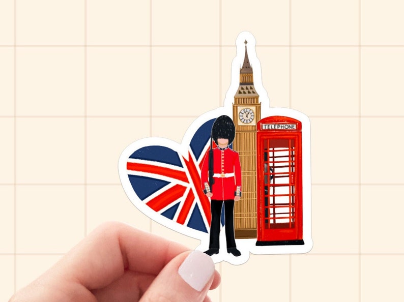 Op de afbeelding: Een sticker met Londense bezienswaardigheden. Het bevat een hartvormige Union Jack, Big Ben, een rode telefooncel en een Royal Guard in een rood uniform. Het ontwerp is een kleurrijke illustratie.