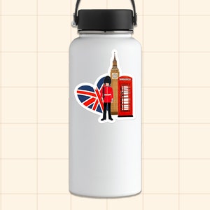 Op de afbeelding: Een witte waterfles met een sticker met Britse symbolen. De sticker toont een hartvormige Union Jack-vlag, een rode telefooncel, Big Ben en een koninklijke garde in een rood uniform.
