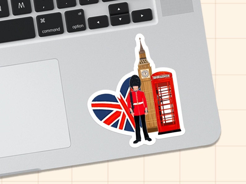 Op de afbeelding: Een sticker met Britse symbolen: Big Ben, een rode telefooncel, een hartvormige Union Jack en een koninklijke garde in een rood uniform. De sticker bevindt zich op een laptop.