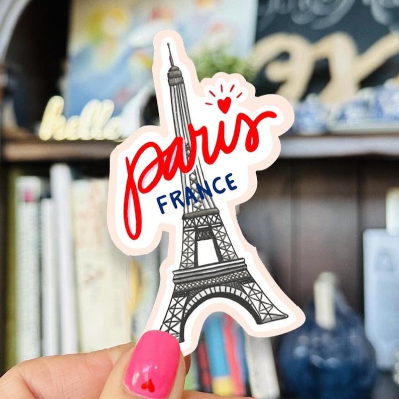 Waterproof die cut stickers of the Eiffel Tower in Paris, France. One Sticker says Paris France . White background, Eiffel Tower is grey, Paris is red, France is blue, blush border.Hand drawn.