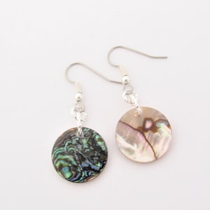 Peut inclure: Une paire de boucles d'oreilles pendantes en argent avec des breloques rondes en nacre d'ormeau. Les breloques sont de couleur vert, bleu et brun irisé.