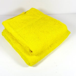 May include: A bright yellow bath towel folded in half. The towel is soft and fluffy.
