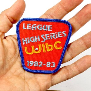 May include: A red and blue embroidered patch with the text "League High Series WIBC 1982-83".