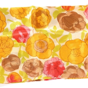 Pode incluir: Um len&ccedil;o de seda com estampa floral amarela, marrom e rosa. O len&ccedil;o tem um fundo branco com um padr&atilde;o repetido de flores.