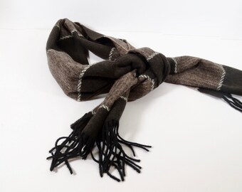 May include: A brown and black striped scarf with black fringe. The scarf is tied in a knot.