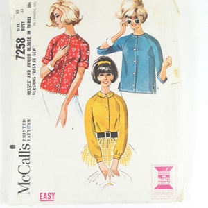 May include: Vintage McCall's sewing pattern for a women's blouse. The pattern is for sizes 13-33 and includes three different versions. The pattern is labeled "Easy to Sew" and is printed on a white background with a pink and blue border.