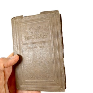 May include: A brown book with the title "An Evening with Thackeray" by Sherwin Cody. The book is part of "The Nutshell Library".