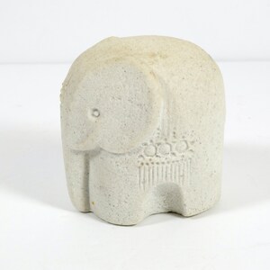 Peut inclure: Une petite figurine d'&eacute;l&eacute;phant en pierre blanche. L'&eacute;l&eacute;phant a une surface textur&eacute;e et un motif d&eacute;taill&eacute; sur son dos.