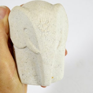 Peut inclure: Figurines d'&eacute;l&eacute;phant en c&eacute;ramique blanche avec une surface textur&eacute;e. La figurine est un design simple avec une t&ecirc;te ronde et de grandes oreilles.