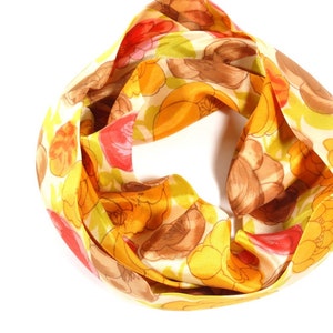 Pode incluir: Um len&ccedil;o estampado em amarelo, vermelho e marrom com desenhos florais.