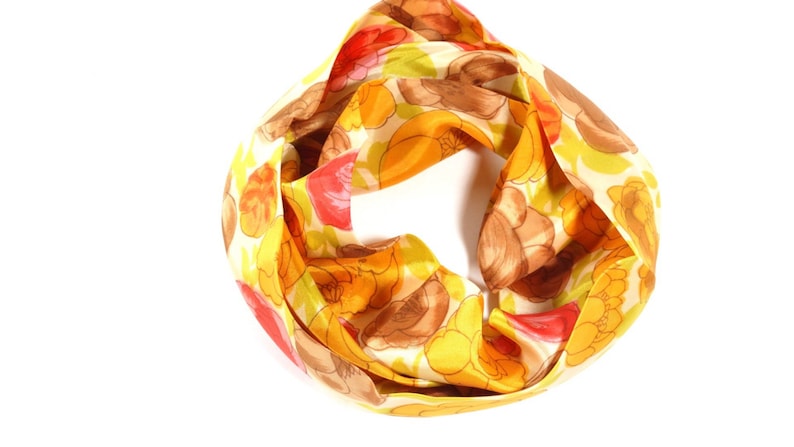 Pode incluir: Um len&ccedil;o estampado em amarelo, vermelho e marrom com desenhos florais.