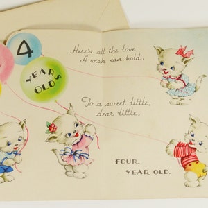 May include: A birthday card with a pop-up design featuring three white kittens holding balloons. The balloons have the words "You are now" and "4 years old" printed on them. The card also has the text "Here's all the love a wish can hold, To a sweet little, dear little, FOUR YEAR OLD."