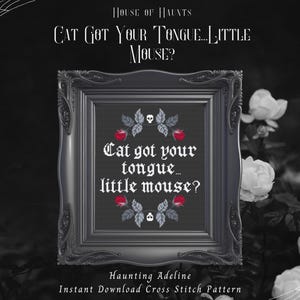 May include: A framed cross-stitch design with the phrase "Cat got your tongue... little mouse?" in a gothic font. The frame is dark grey and ornate. The design features red roses and skull accents, set against a dark background.