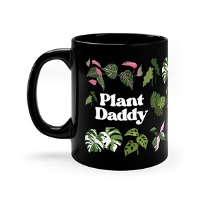 May include: Black ceramic mug with a white graphic of various plants and the text "Plant Daddy".