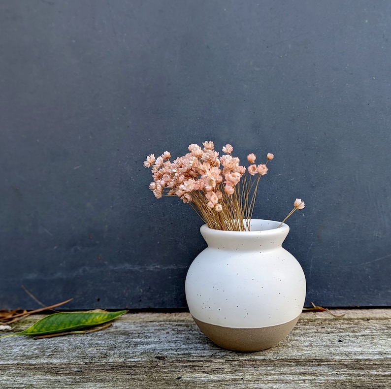 tiny ceramic cream and brown speckled vase with optional pink or yellow dried flowers.