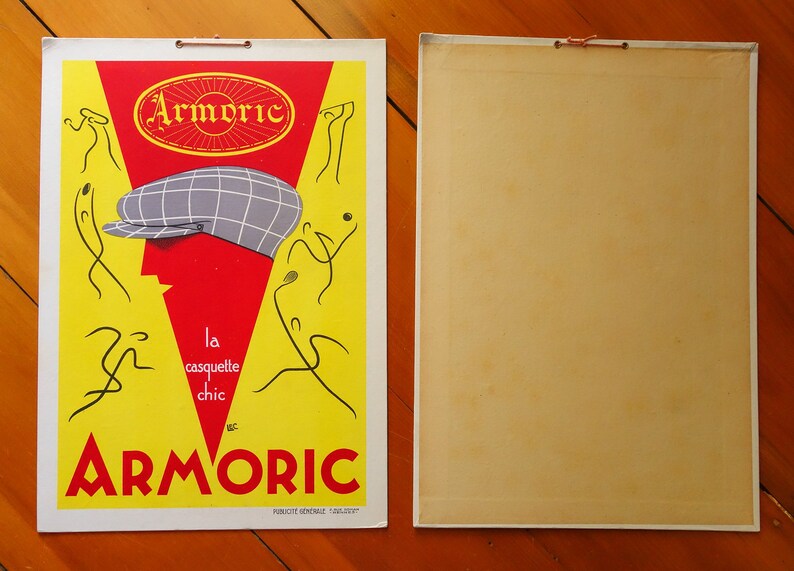 May include: A vintage advertisement for Armoric brand caps. The ad features a red and yellow background with a stylized illustration of a person wearing a plaid cap. The text reads "Armoric, la casquette chic".