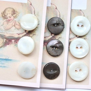 May include: Assortment of eight round buttons, four white and four black. The white buttons are made of mother of pearl and have a smooth, shiny finish. The black buttons are made of a textured material and have a subtle sheen.