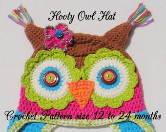 May include: A crocheted owl hat for babies and toddlers, with a pink, green, blue, and brown color scheme. The hat has a flower on top and two long braided ties. The hat is labeled "Hootie Owl Hat" and "Crochet Pattern size 12 to 24 months".