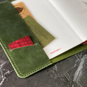 May include: A green leather notebook cover with a red card holder and the text "LEUCHTTURM1917" on the inside of the cover.