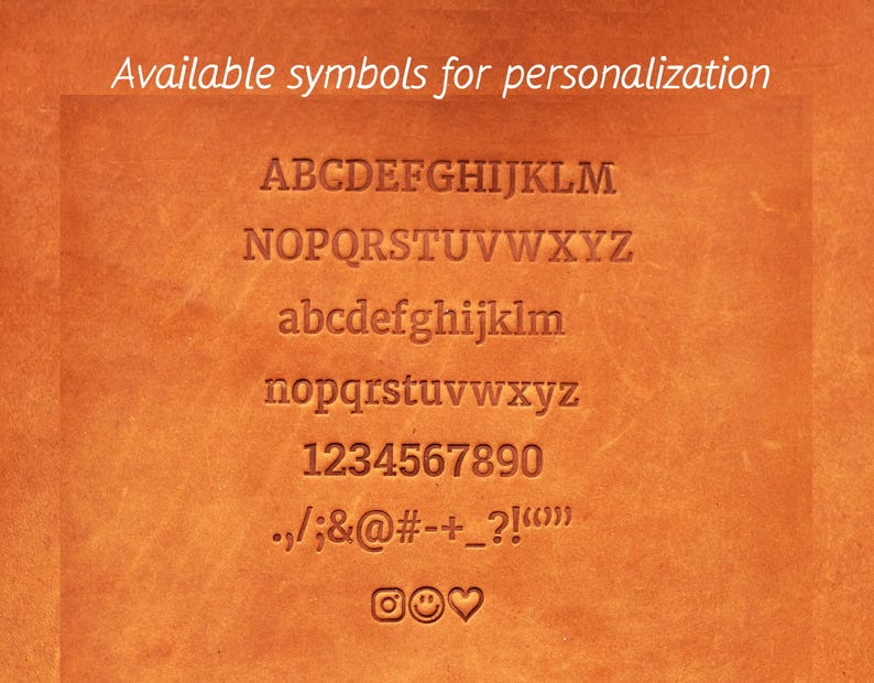 Puede incluir: Primer plano de una superficie de cuero marr&oacute;n con una lista de s&iacute;mbolos disponibles para la personalizaci&oacute;n. Los s&iacute;mbolos incluyen letras may&uacute;sculas y min&uacute;sculas, n&uacute;meros, signos de puntuaci&oacute;n y algunos emojis.