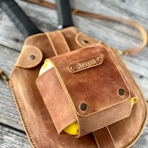 Puede incluir: Un cintur&oacute;n de herramientas de cuero marr&oacute;n con una peque&ntilde;a bolsa que tiene el nombre "Aragon" grabado en &eacute;l. La bolsa est&aacute; unida al cintur&oacute;n con remaches de lat&oacute;n.