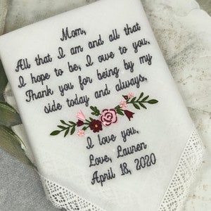 May include: White embroidered handkerchief with a floral design and the text "Mom, All that I am and all that I hope to be, I owe to you. Thank you for being by my side today and always, I love you. Love, Lauren April 18, 2020".