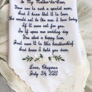 May include: White embroidered handkerchief with a message to a mother-in-law. The message reads: "To My Mother-In-Law, Your son is such a special man, And I know that it is true, He would not be the man I love today If it were not for you. So if upon our wedding day You shed a happy tear, Just save it in this handkerchief And know I hold you dear. Love, Cheyenne July 24, 2021"