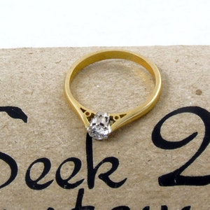Pu&ograve; includere: Un anello di fidanzamento con fascia in oro con un singolo diamante rotondo incastonato in una delicata montatura a griffe.