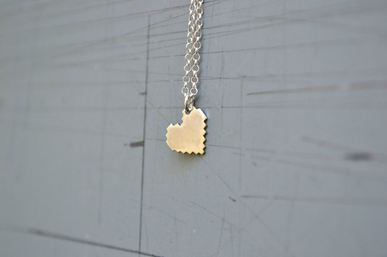 May include: A silver chain necklace with a pixelated heart pendant.
