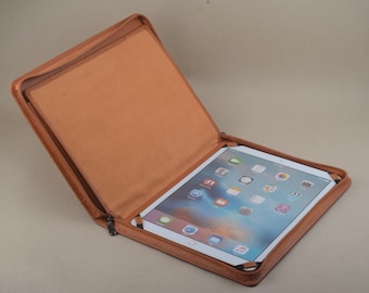 May include: A brown leather case with a zipper closure, open to reveal a tablet computer with a bright blue screen displaying various icons.