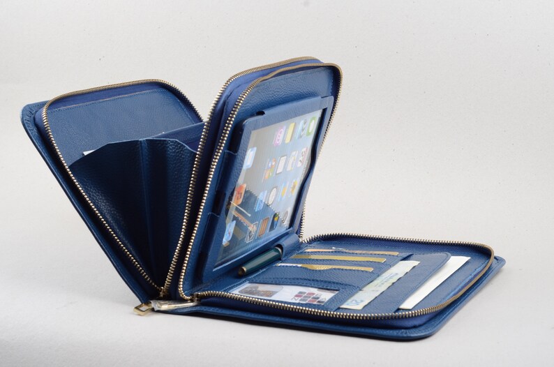 May include: A blue leather zippered case with a clear plastic window for a tablet, multiple card slots, and a pen holder.